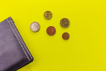 Black leather Men's Wallet with Euro coins on yellow background