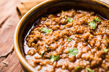 Kheema / keema Pav or Khima Paav is a spicy curry dish made up of minced chicken or lamb cooked with onion, tomatoes, served with buns. selective focus