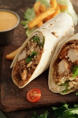 Burritos Wrap with grilled chicken rice and veggies on wooden background, selective focus