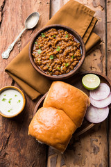 Kheema / keema Pav or Khima Paav is a spicy curry dish made up of minced chicken or lamb cooked with onion, tomatoes, served with buns. selective focus