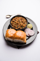 Kheema / keema Pav or Khima Paav is a spicy curry dish made up of minced chicken or lamb cooked with onion, tomatoes, served with buns. selective focus