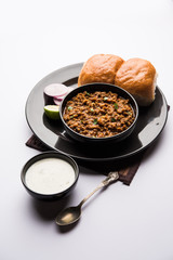 Kheema / keema Pav or Khima Paav is a spicy curry dish made up of minced chicken or lamb cooked with onion, tomatoes, served with buns. selective focus