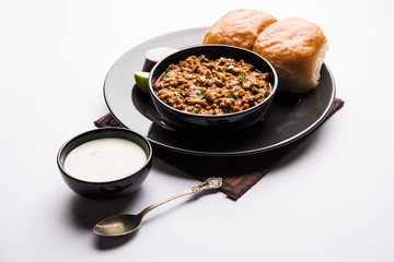 Kheema / keema Pav or Khima Paav is a spicy curry dish made up of minced chicken or lamb cooked with onion, tomatoes, served with buns. selective focus