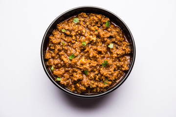 Kheema / keema Pav or Khima Paav is a spicy curry dish made up of minced chicken or lamb cooked with onion, tomatoes, served with buns. selective focus