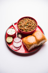 Kheema / keema Pav or Khima Paav is a spicy curry dish made up of minced chicken or lamb cooked with onion, tomatoes, served with buns. selective focus