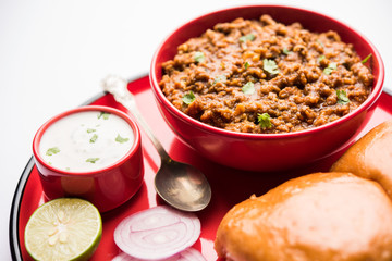 Kheema / keema Pav or Khima Paav is a spicy curry dish made up of minced chicken or lamb cooked with onion, tomatoes, served with buns. selective focus