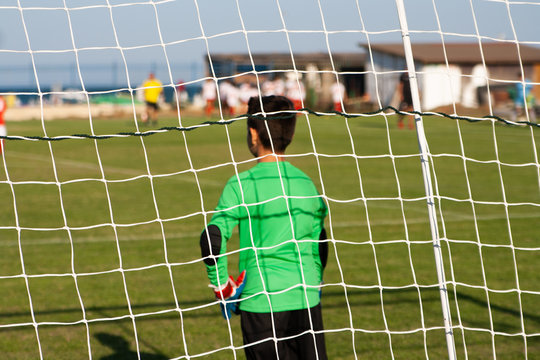 Kids soccer football - young children players match on soccer field near a sea