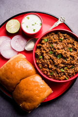 Kheema / keema Pav or Khima Paav is a spicy curry dish made up of minced chicken or lamb cooked with onion, tomatoes, served with buns. selective focus