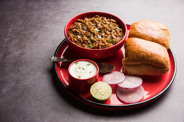 Kheema / keema Pav or Khima Paav is a spicy curry dish made up of minced chicken or lamb cooked with onion, tomatoes, served with buns. selective focus