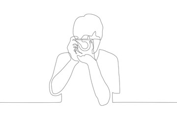 one continuous line art of a male holding and looking at the camera aimed at the viewer. Professional photographer takes photos. It can be used for animation. Vector