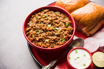 Kheema / keema Pav or Khima Paav is a spicy curry dish made up of minced chicken or lamb cooked with onion, tomatoes, served with buns. selective focus