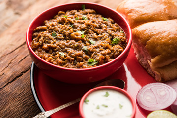Kheema / keema Pav or Khima Paav is a spicy curry dish made up of minced chicken or lamb cooked with onion, tomatoes, served with buns. selective focus