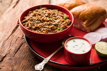 Kheema / keema Pav or Khima Paav is a spicy curry dish made up of minced chicken or lamb cooked with onion, tomatoes, served with buns. selective focus