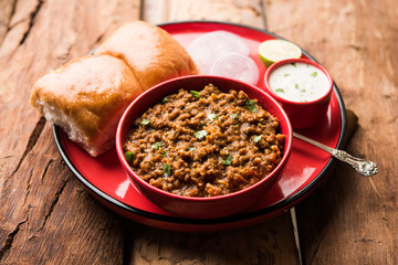 Kheema / keema Pav or Khima Paav is a spicy curry dish made up of minced chicken or lamb cooked with onion, tomatoes, served with buns. selective focus