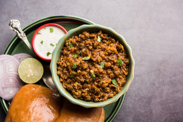 Kheema / keema Pav or Khima Paav is a spicy curry dish made up of minced chicken or lamb cooked with onion, tomatoes, served with buns. selective focus