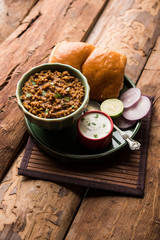 Kheema / keema Pav or Khima Paav is a spicy curry dish made up of minced chicken or lamb cooked with onion, tomatoes, served with buns. selective focus