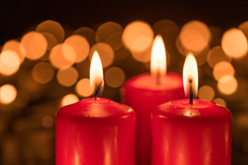 Three burning candles on the third Sunday of Advent