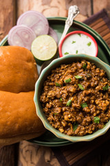 Kheema / keema Pav or Khima Paav is a spicy curry dish made up of minced chicken or lamb cooked with onion, tomatoes, served with buns. selective focus