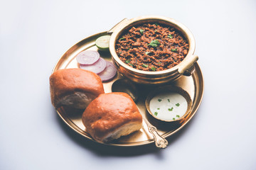 Kheema / keema Pav or Khima Paav is a spicy curry dish made up of minced chicken or lamb cooked with onion, tomatoes, served with buns. selective focus