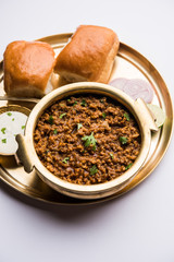 Kheema / keema Pav or Khima Paav is a spicy curry dish made up of minced chicken or lamb cooked with onion, tomatoes, served with buns. selective focus