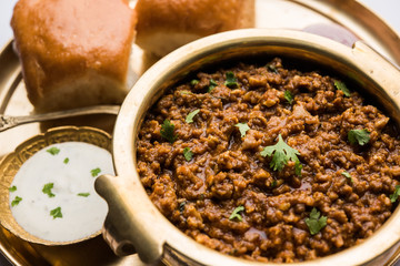 Kheema / keema Pav or Khima Paav is a spicy curry dish made up of minced chicken or lamb cooked with onion, tomatoes, served with buns. selective focus