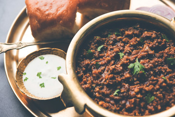 Kheema / keema Pav or Khima Paav is a spicy curry dish made up of minced chicken or lamb cooked with onion, tomatoes, served with buns. selective focus