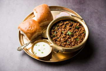 Kheema / keema Pav or Khima Paav is a spicy curry dish made up of minced chicken or lamb cooked with onion, tomatoes, served with buns. selective focus