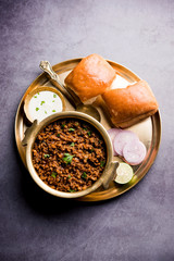 Kheema / keema Pav or Khima Paav is a spicy curry dish made up of minced chicken or lamb cooked with onion, tomatoes, served with buns. selective focus