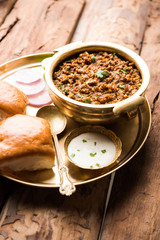 Kheema / keema Pav or Khima Paav is a spicy curry dish made up of minced chicken or lamb cooked with onion, tomatoes, served with buns. selective focus