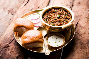 Kheema / keema Pav or Khima Paav is a spicy curry dish made up of minced chicken or lamb cooked with onion, tomatoes, served with buns. selective focus