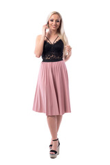 Young happy woman in elegant style fashion walking and talking on cellphone looking down. Full body isolated on white background. 