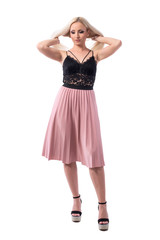 Young well dressed blond hair woman in elegant fashion tossing hair getting ready. Full body isolated on white background. 