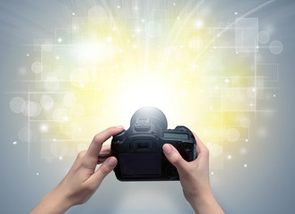 Naked hand taking picture with digital camera and glowing flash concept