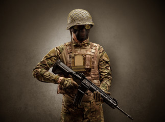 Soldier agent in a dark room with arms on his hand and gas mask