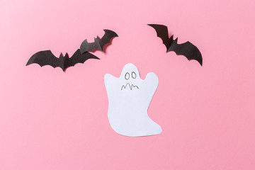 White ghost costume against a pastel pink background. Minimal Halloween scary concept. craft paper ghosts