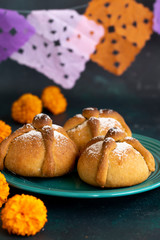 Mexican celebration, bread of death. Mexican parties with Dead bread and marigold flowers on gray stone background. Traditional Mexican Bread of the Dead Pan de Muerto .