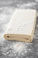Fresh raw dough on table. Puff pastry. Copy space.
