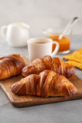 Freshly baked croissants and coffee cup on grey table. Copy space.