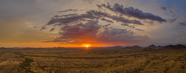 A panorama of a sunset over the Sonoran Desert take by a drone with lots of colorful clouds on the horizon