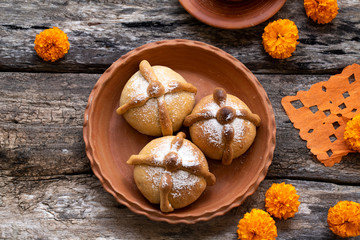 Mexican celebration, bread of death. Mexican parties Dead bread and marigold flowers on wooden rustic background. Traditional Mexican Bread of the Dead Pan de Muerto , Top view, Copy space.