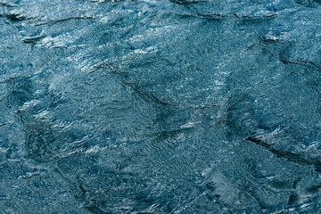 Background texture shot of dark blue water ripple