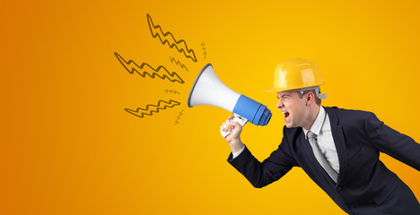 Fototapeta premium Young architect constructor yelling with megaphone and copyspace