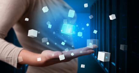 Person holding hologram projection displaying white cubes in server room