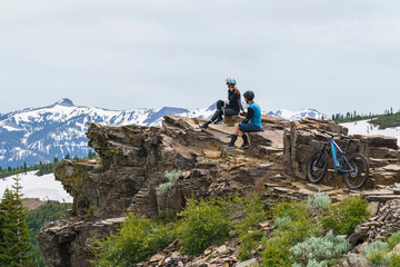 mountain bike couple on rock looking at scenery 