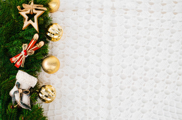 Christmas banner, horizontal layout. On the right side, spruce branches are vertically decorated with decorative Christmas toys: star, ski, sock. The main background is knitted textile in white. Copy