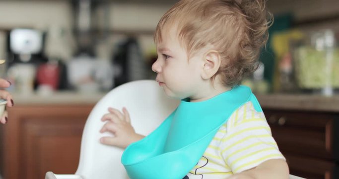 Infant boy fed soup with a spoon