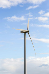 modern windmill on a sunny day and with idyllic white clouds, closeup of the foreground, Energy concept