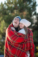 Winter walk through the woods. The guy in the red plaid blanket wraps the girl up so she gets warm