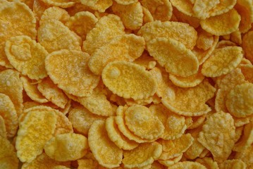 yellow natural texture of a pile of small dried corn flakes