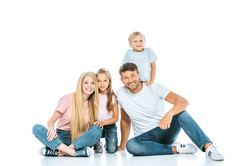 happy parents and children in blue denim jeans sitting on white